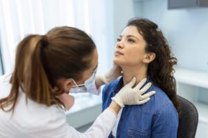 Endocrinologist examines patient’s throat