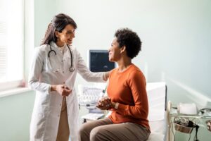 Female doctor reassuring female patient in examination room