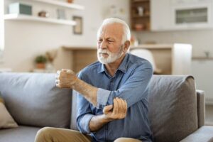 Senior man with elbow pain caused by gout